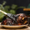 Stainless steel silicone brush basting a pork shoulder
