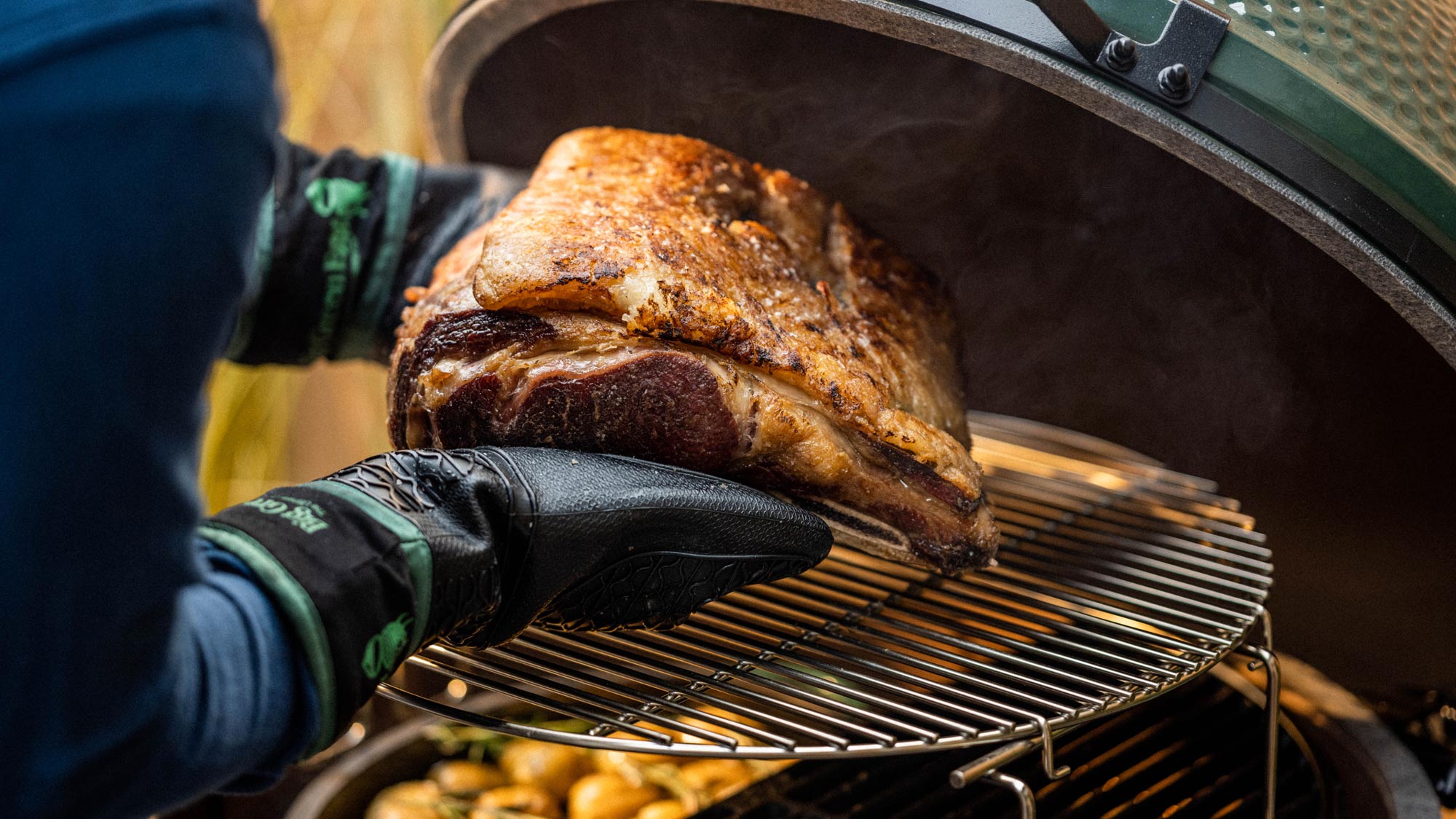 Heat Resistant Silicone BBQ Mitt with Fabric Cuff holding a rib of beef