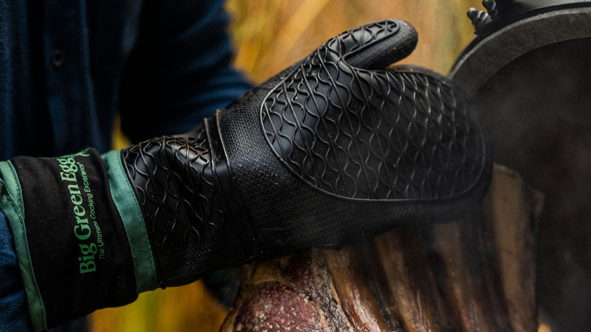 Heat Resistant Silicone BBQ Mitt with Fabric Cuff holding a rib of beef