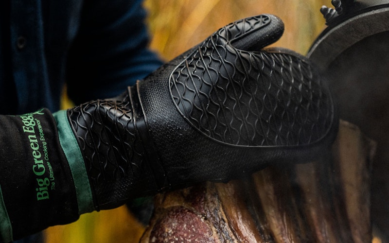 Heat Resistant Silicone BBQ Mitt with Fabric Cuff holding a rib of beef