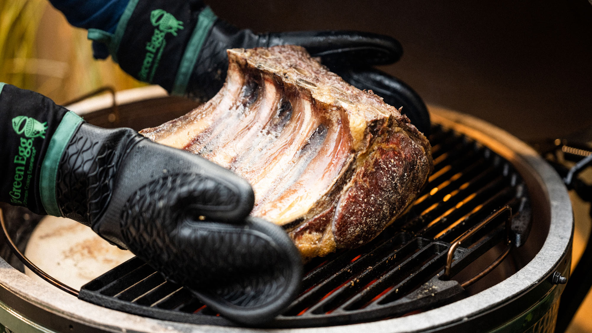 Heat Resistant Silicone BBQ Mitt with Fabric Cuff holding a rib of beef