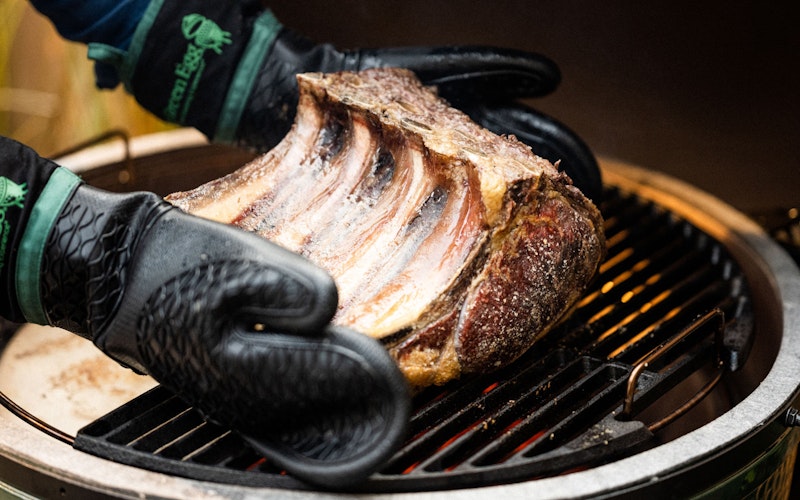 Heat Resistant Silicone BBQ Mitt with Fabric Cuff holding a rib of beef